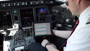 pilot checking web manuals on efb in airplane cockpit
