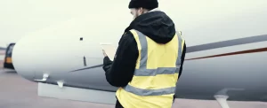 MRO checking web manuals on EFB ipad in front of airplane